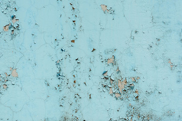 light coloured blue peeling paint on the old rough concrete surface