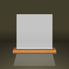 White translucent frame on a wooden shelf on a dark background.