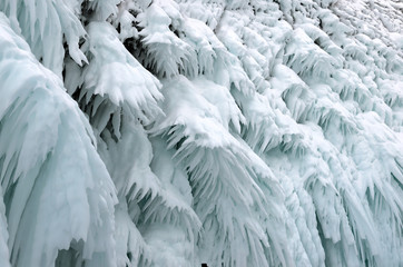 Ice splashes of waves on shores of Baikal, Ice blocks and icicles on coast rocks.