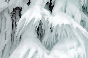 Ice splashes of waves on shores of Baikal, Ice blocks and icicles on coast rocks.