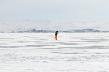 Man skiing through snow and ice surface Lake Baikal