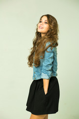 Young brunette woman in a black skirt and blue jeans jacket