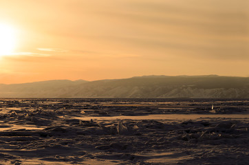 Sunset over ice surface of Strait Small Sea of Lake Baikal