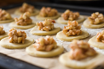 Round shortbread with apple filling on a protvine in the oven