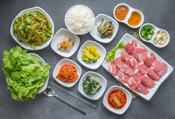 Set of slice raw pork ready to grill korean style, include slide food with vegetable and rice.