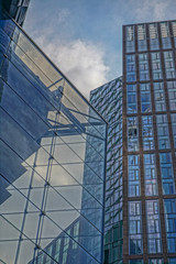 Abstract patterns formed by the reflections of buildings  in the glass facade of a modern office building.
