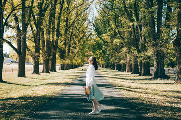 Fototapeta premium fashion young woman walking in the park in autumn 