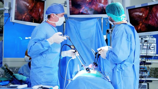 Medical Multi ethnic training hospital performing Laparoscopy operation carried out using Endoscopy and Laparoscope instrument with video monitor playback 
