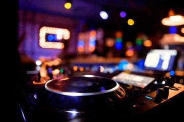 Fototapeta na wymiar control DJ for mixing music with blurred people dancing at party in nightclub