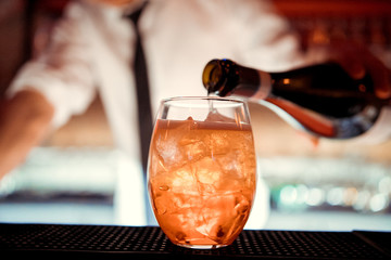 The barman pours Aperol into the cocktail of Aperol Spritz close up