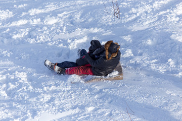 People sledding from the mountain in winter