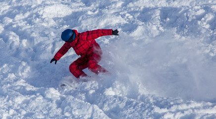 Naklejka na ściany i meble A man snowboarding a mountain in the snow in winter