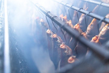 Fish smoked on hooks in smokehouse