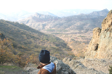 Fototapeta na wymiar A boy standing above the mountain range.