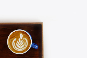 a cup of latte art coffee on wooden background