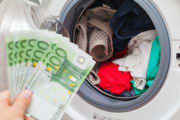 Holding money in front of washing machine