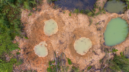 Holes on ground from powerful explosions. Bomb craters in the forest. Disposal of explosives. Top view aerial photo from flying drone. © Artem Zarubin