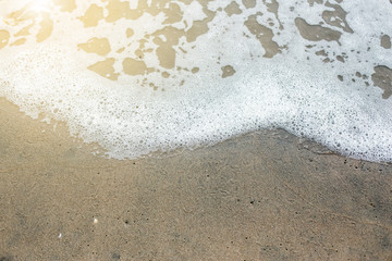 Wave of the sea on the sand beach with sunlight , for background