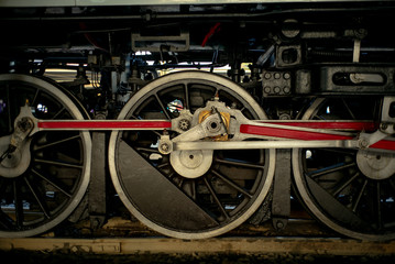 Closeup texture and background of steel locomotive wheel of vintage steam train atopping at the train station