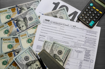 Tax form 1040, dollars, pen, calculator and notepad