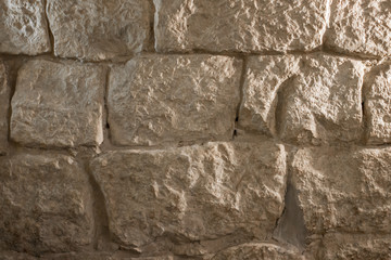 Stonework wall. The texture of a large stone. The architecture of the old castle. Medieval building. Construction material. Imitation lumps. Rough surface.