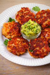 Salmon burgers with avocado salsa and lime. Salmon cakes. Fish patties. vertical