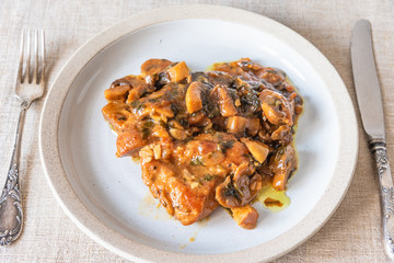 Italian cuisine - Marsala chicken with mushrooms on a plate, top view