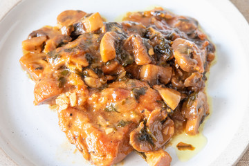 Italian cuisine - Marsala chicken with mushrooms on a plate, closeup