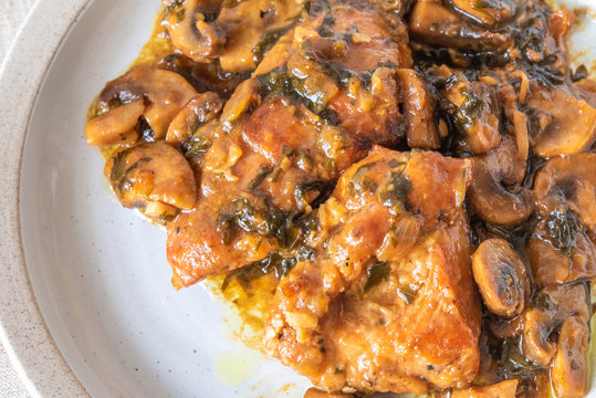 Italian cuisine - Marsala chicken with mushrooms on a plate, closeup