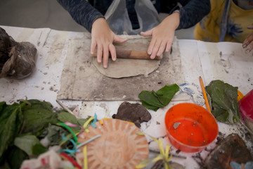 master shapes pottery on a blue canvas. Creative process. Gives shape to your product.Spread the clay with a rolling pin