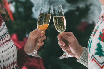 Hands holding glasses toasting for Christmas
