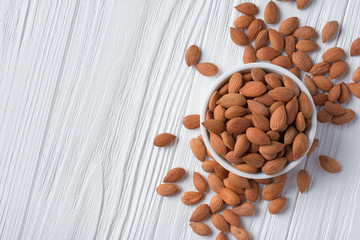 Top view of healthy whole almond in white bowl