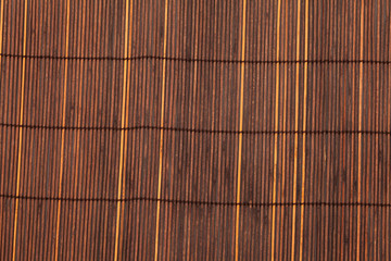 Sunburned bamboo matt background. Texture of asian mat from brown yellow bamboo. Super macro, close up image