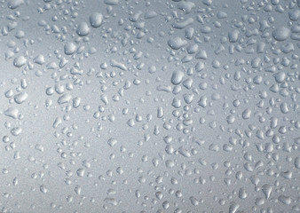 Dew droplets  twinkle on car's rar window. Condensation on the outside of a sillvercar in early cold morning hours.