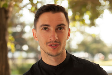 portrait of a smiling young man. young brunette man rejoices, happy man, pleasure and satisfaction