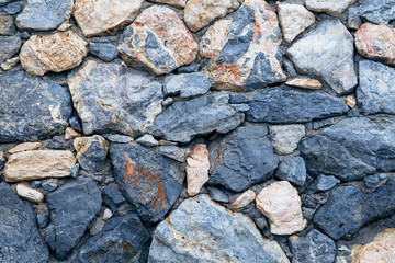 old stone wall of stones of different sizes and colors as a natural background
