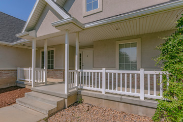 Fototapeta na wymiar Facade of home with stairs yard and sunlit porch