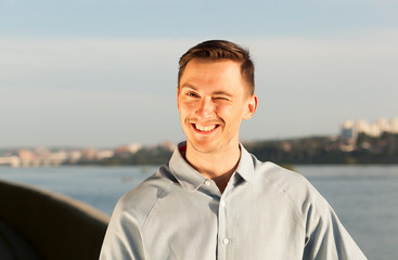 portrait of a smiling young man. young brunette man rejoices, happy man, pleasure and satisfaction