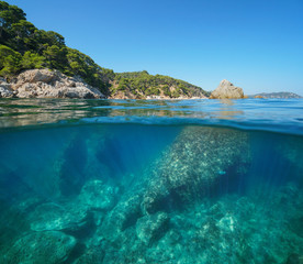 Rocky coastline with large rocks underwater sea, split view half above and below water surface, Cala del Crit, Mediterranean, Palamos, Costa Brava, Spain
