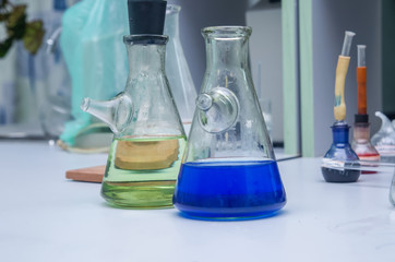 Laboratory glassware with multi-colored liquid on table. Chemical analysis