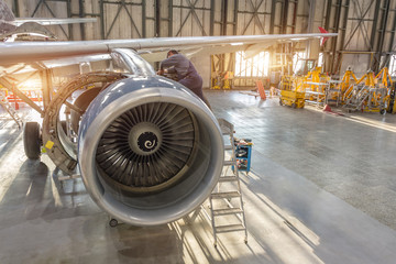 Aircraft engine repair, mechanic installs reverse hoods.