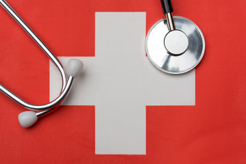 Swiss flag and stethoscope. The concept of medicine.