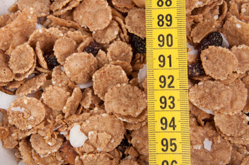 organic cereal in beige bowl with tape measure Diet food.