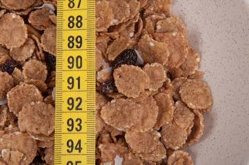 organic cereal in beige bowl with tape measure Diet food.