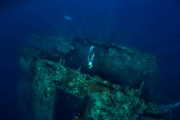 Freediver man dive at shipwreck, underwater