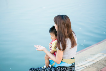 Baby boy riding in infant carrier by mother outdoors