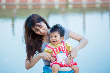 Smiling mother and baby playing in park