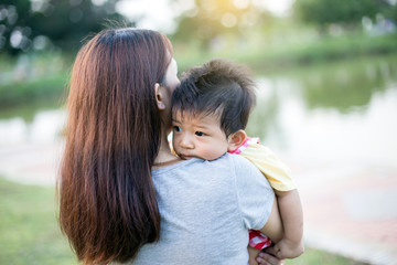 Young mother with her little son in summer park