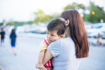 Young mother with her little son in summer park