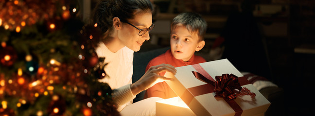Boy and his mother opening Christmas gifts